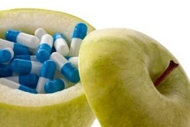 Ausgehöhlter Apfel mit Medikamentenkapseln gefüllt