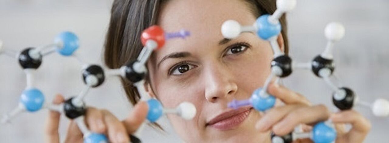 Junge Frau sieht sich ein Molekülmodell an