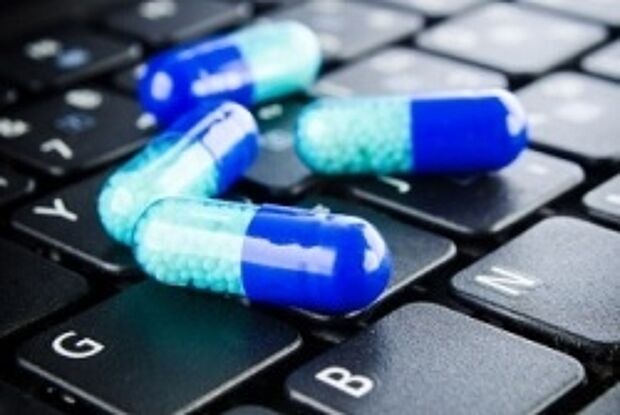 Medikamentenkapseln auf einer Computertastatur