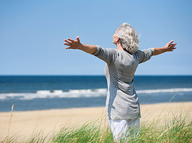 Grauhaarige Frau am Meer
