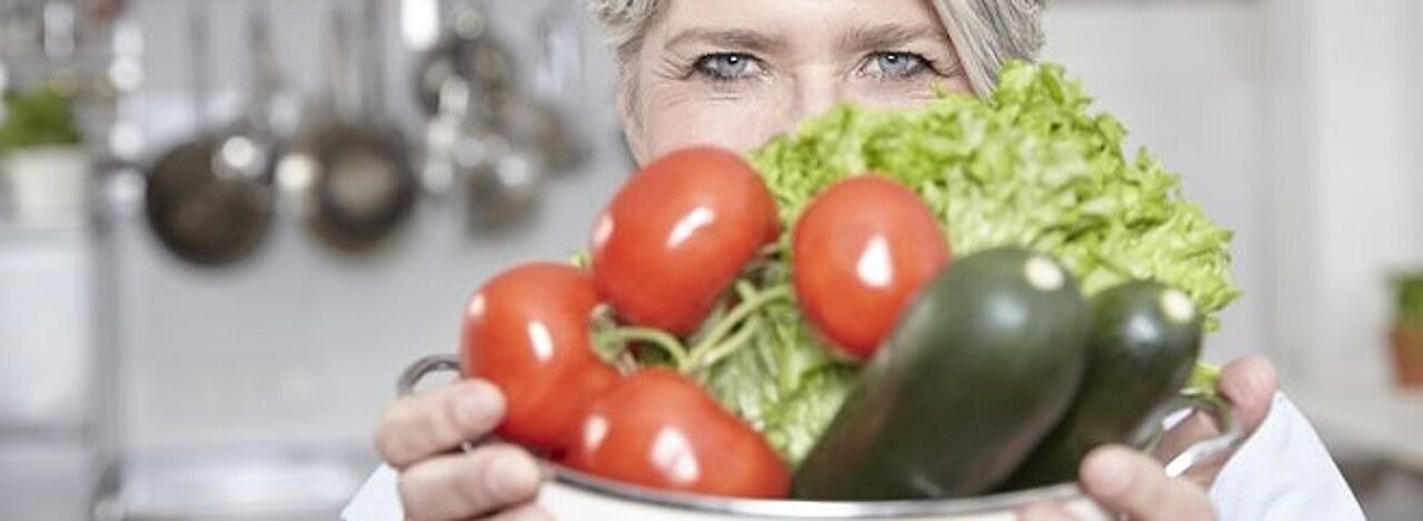 Älter Frau hält eine Schüssel mit Gemüse