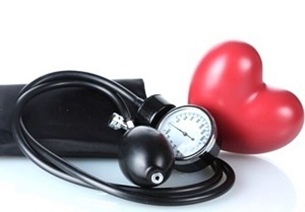 Blutdruckmanschette und Herz vor weißem Hintergrund