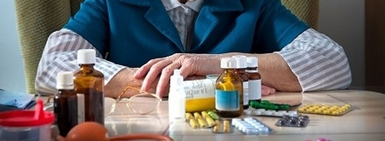 Ältere Frau vor vielen Tabletten