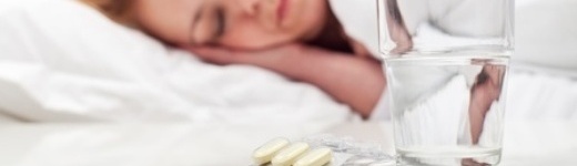 Antibiotika - Schlafende Frau mit Medikamenten und Wasserglas auf Nachttisch Antibiotika - Schlafende Frau mit Medikamenten und Wasserglas auf Nachttisch