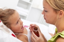 Medikamente bei Kindern und Jugendlichen - Mutter gibt Tochter einen Löffel voll Medizin Medikamente bei Kindern und Jugendlichen - Mutter gibt Tochter einen Löffel voll Medizin