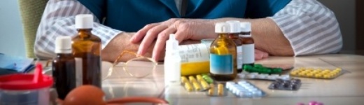 Missbrauch und Abhängigkeit von Medikamenten - ältere Frau vor vielen Tabletten Missbrauch und Abhängigkeit von Medikamenten - ältere Frau vor vielen Tabletten