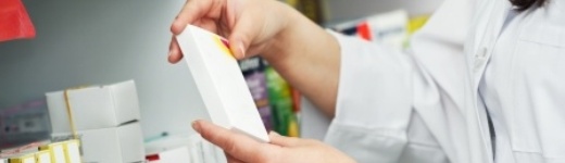 Apothekerin nimmt Medikamente aus Regal Apothekerin nimmt Medikamente aus Regal