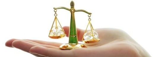 Eine Hand hält eine kleine Pendelwaage Eine Hand hält eine kleine Pendelwaage