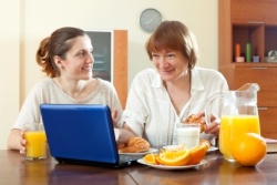 Wechselwirkungen zwischen Medikamenten und Nahrungsmitteln - Mutter und Tochter am Frühstückstisch mit Orangensaft und Milch Wechselwirkungen zwischen Medikamenten und Nahrungsmitteln - Mutter und Tochter am Frühstückstisch mit Orangensaft und Milch