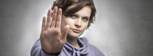 Junge Frau macht mit der Hand Stopp-Zeichen Junge Frau macht mit der Hand Stopp-Zeichen